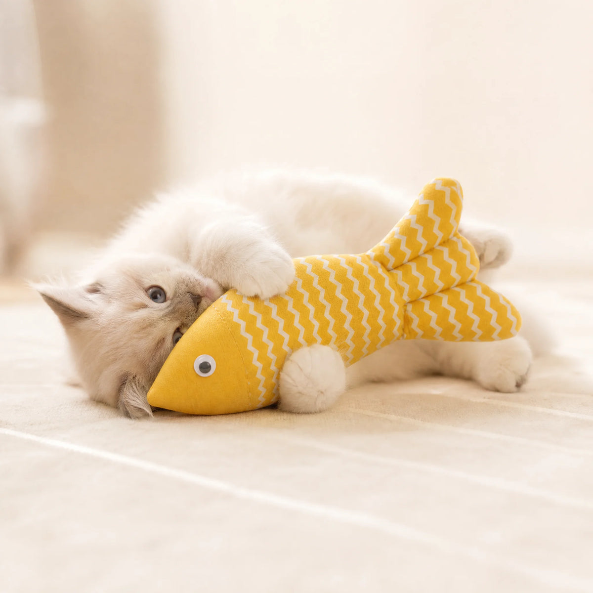 The fishbone cat toy in yellow, showing its 21 cm length